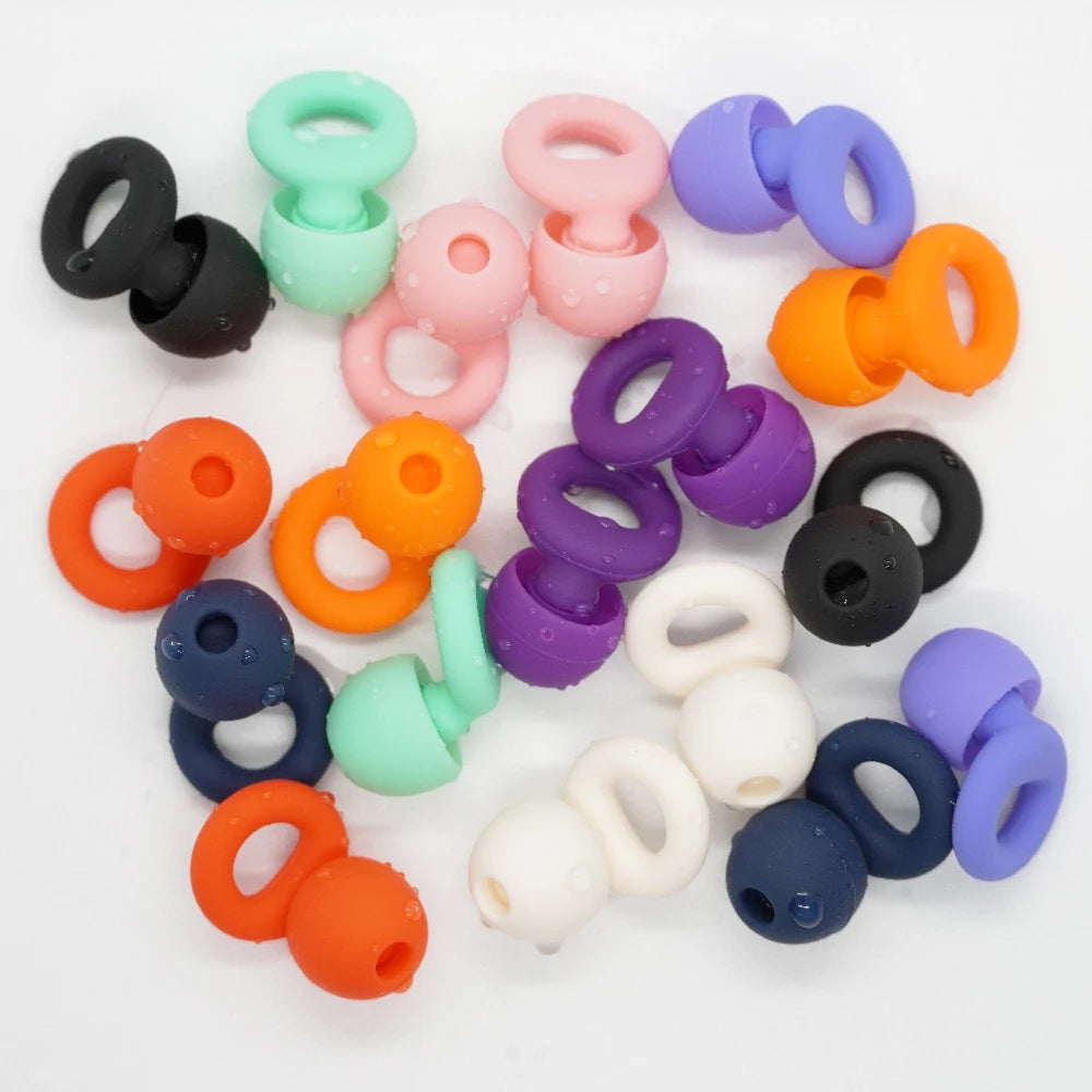 Reusable silicone earplugs and spare tips scattered on a white surface in black, mint, pink, purple, orange, cream and navy